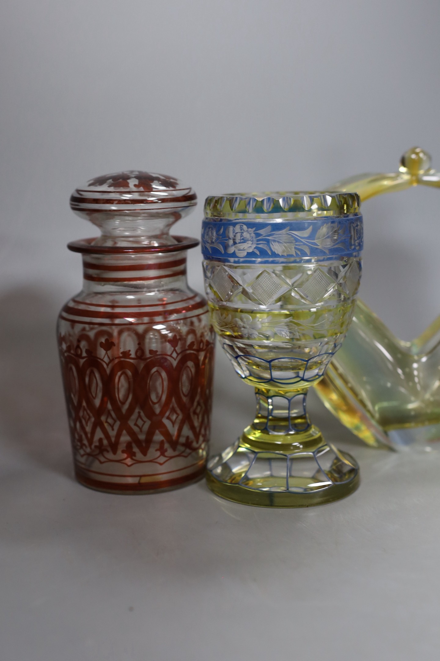 A Bohemian yellow and blue glass goblet, red overlaid vase and cover, another glass jar and cover and a Murano basket, tallest 24cm